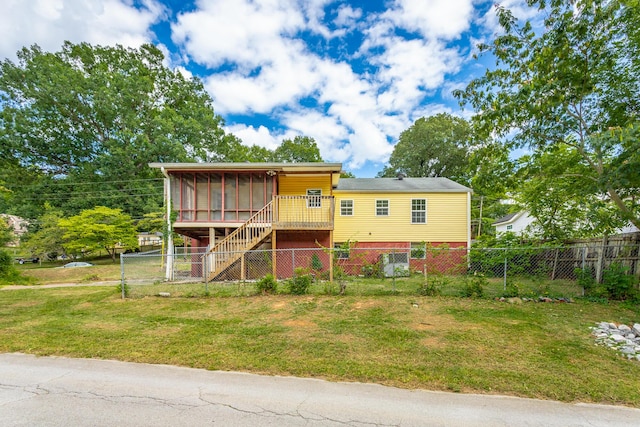 view of front of house featuring a front yard and a sunroom