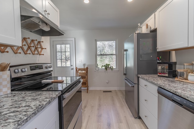 kitchen featuring light hardwood / wood-style floors, light stone countertops, white cabinets, and stainless steel appliances