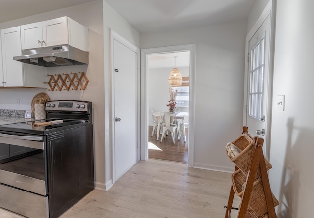 kitchen with white cabinets, electric range, light wood-type flooring, and hanging light fixtures