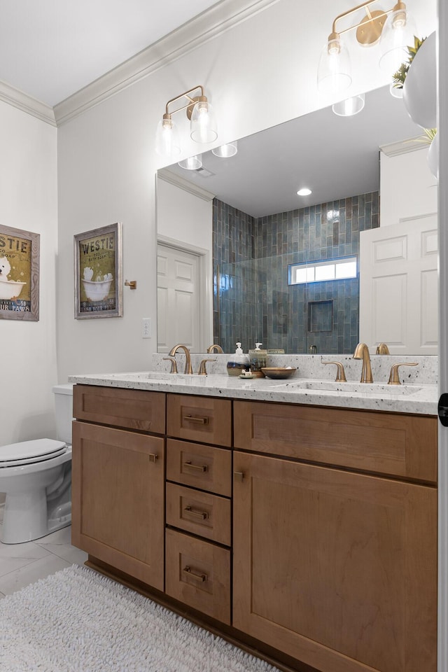 bathroom featuring tiled shower, vanity, toilet, and ornamental molding