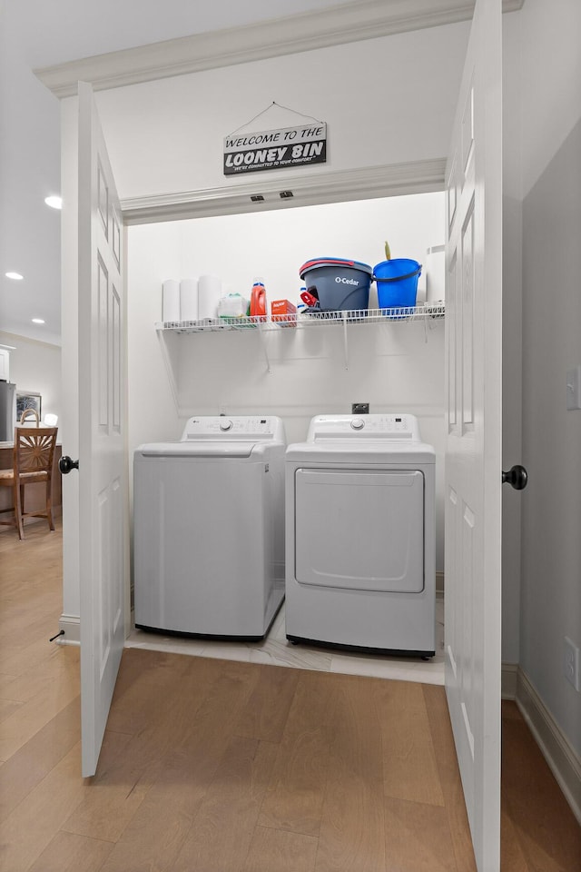 clothes washing area featuring separate washer and dryer and light hardwood / wood-style flooring