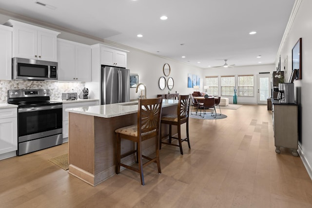 kitchen with white cabinetry, sink, an island with sink, and appliances with stainless steel finishes