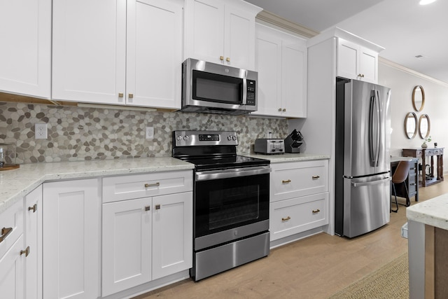 kitchen featuring light stone counters, white cabinets, stainless steel appliances, light hardwood / wood-style floors, and backsplash