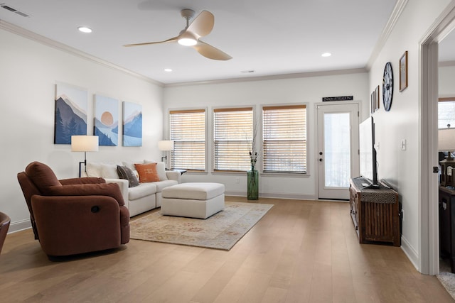 living room with crown molding, ceiling fan, and light hardwood / wood-style flooring