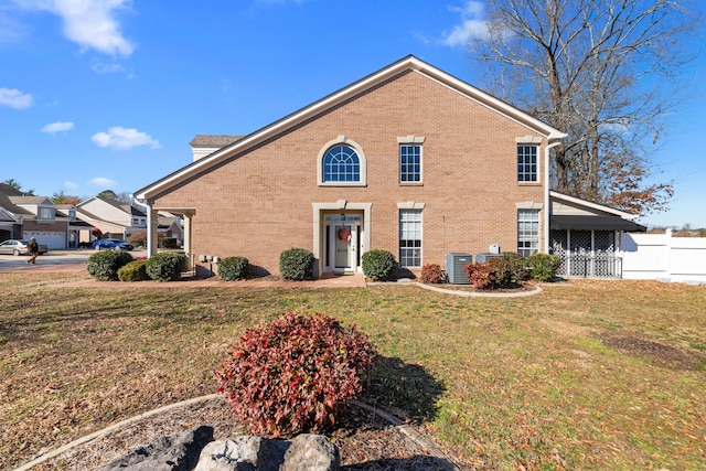 view of front property with central AC and a front lawn