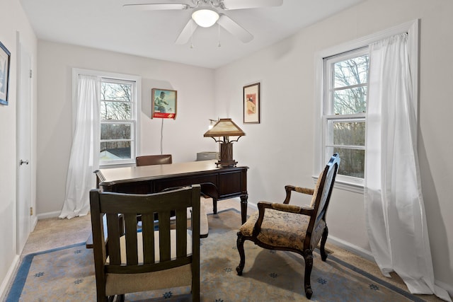 carpeted office space featuring ceiling fan