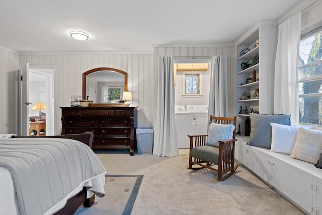 bedroom featuring ornamental molding, separate washer and dryer, and light carpet