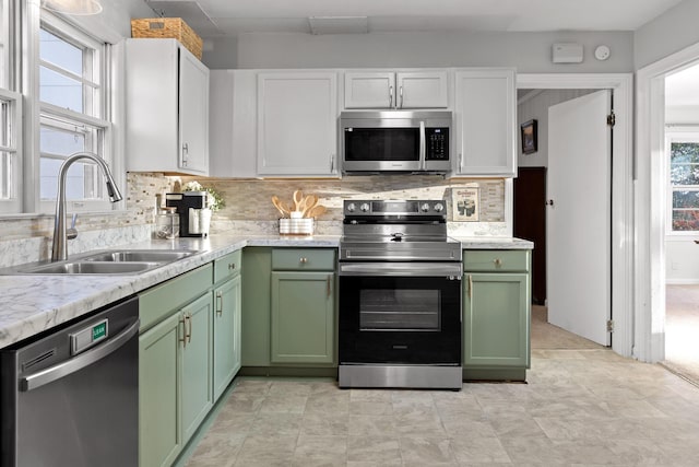 kitchen with stainless steel appliances, white cabinetry, sink, and green cabinetry