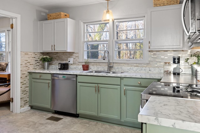 kitchen with pendant lighting, sink, white cabinets, and appliances with stainless steel finishes