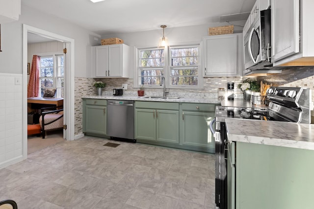 kitchen featuring pendant lighting, sink, green cabinetry, and appliances with stainless steel finishes