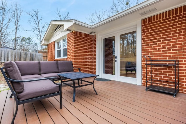 wooden terrace with an outdoor living space