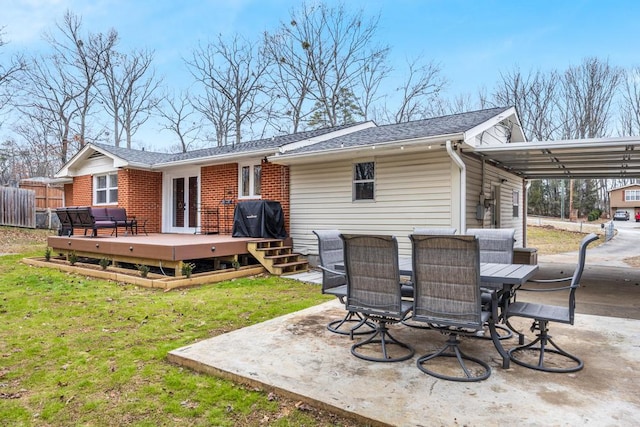 back of house with a wooden deck, a lawn, and a patio