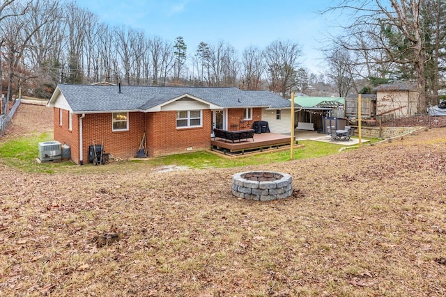 rear view of house featuring a deck, a fire pit, and central AC