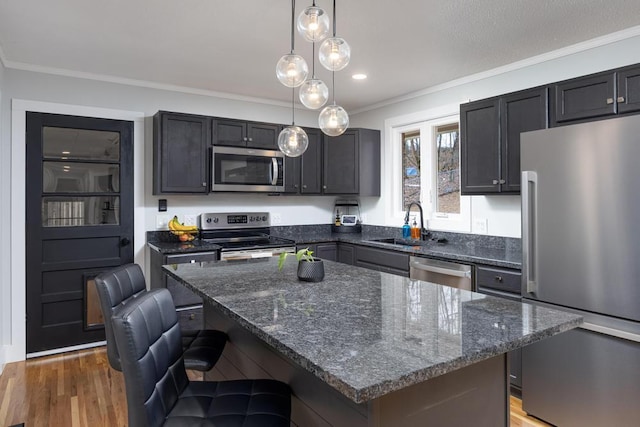 kitchen featuring decorative light fixtures, dark stone countertops, a kitchen island, a breakfast bar area, and stainless steel appliances