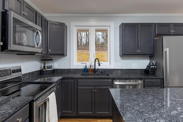 kitchen with sink, dark stone countertops, crown molding, and appliances with stainless steel finishes