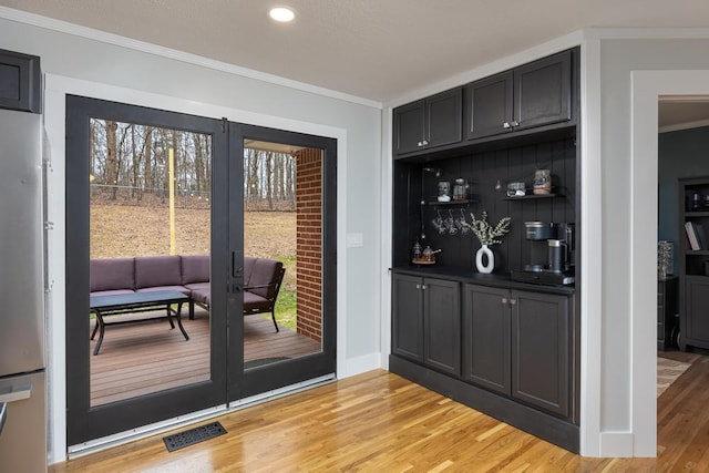 doorway to outside with crown molding and light hardwood / wood-style floors