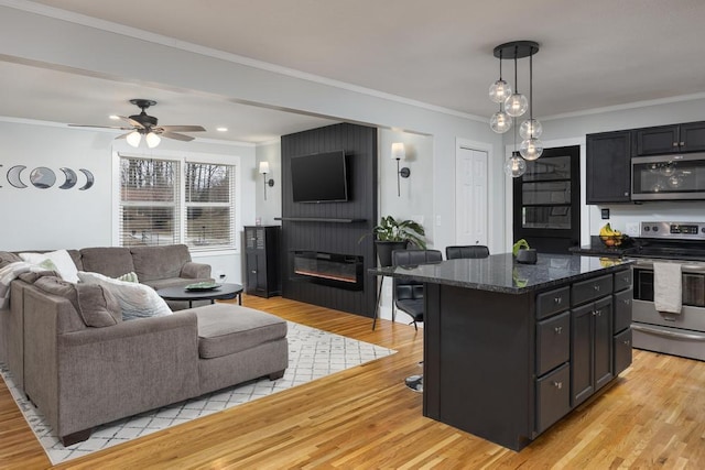 kitchen featuring a breakfast bar area, a kitchen island, crown molding, and appliances with stainless steel finishes