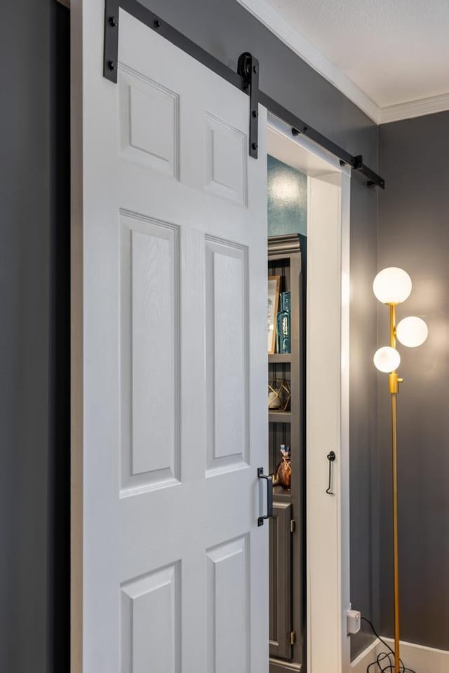 interior details with crown molding and a barn door