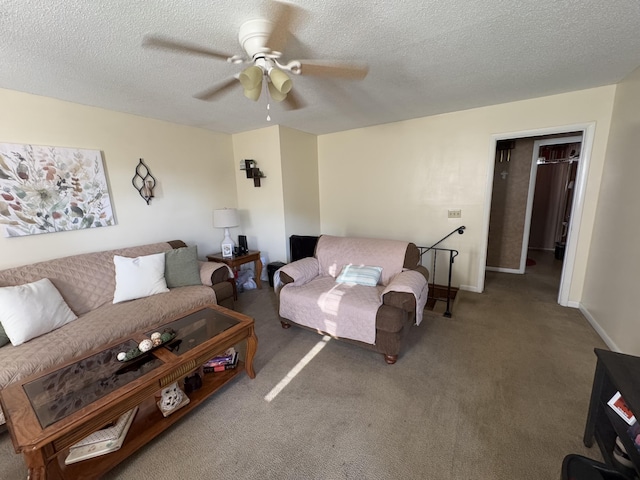 carpeted living room featuring ceiling fan and a textured ceiling