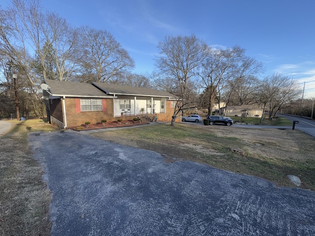 single story home featuring covered porch and a front lawn