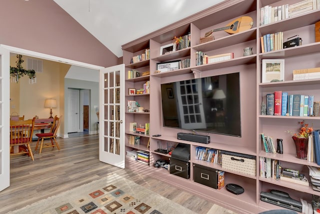 living area with french doors, vaulted ceiling, and hardwood / wood-style floors