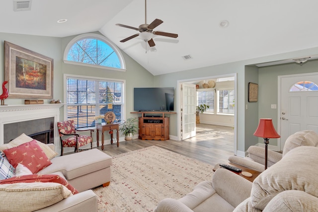 living room with lofted ceiling, light hardwood / wood-style flooring, and ceiling fan