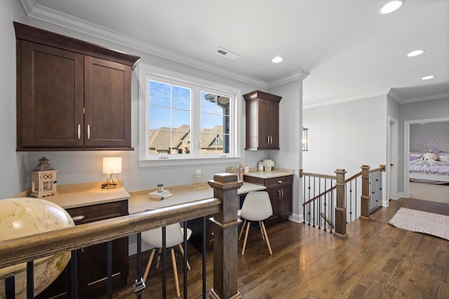 dining area with crown molding and dark wood-type flooring