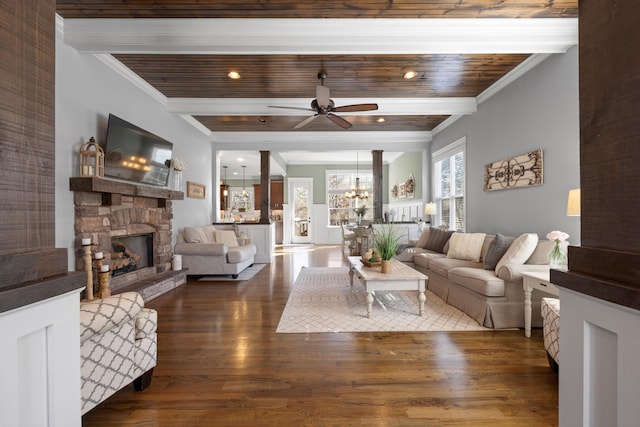 living room featuring crown molding, a stone fireplace, beamed ceiling, and hardwood / wood-style flooring