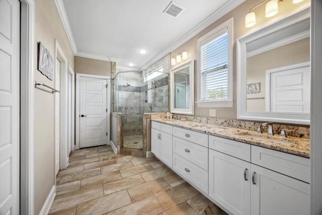 bathroom with vanity, crown molding, and a shower with shower door