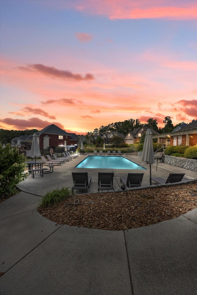 pool at dusk featuring a patio area