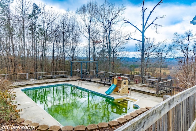 view of pool with a wooden deck and a patio