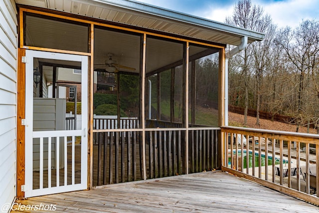 wooden terrace featuring ceiling fan and a sunroom