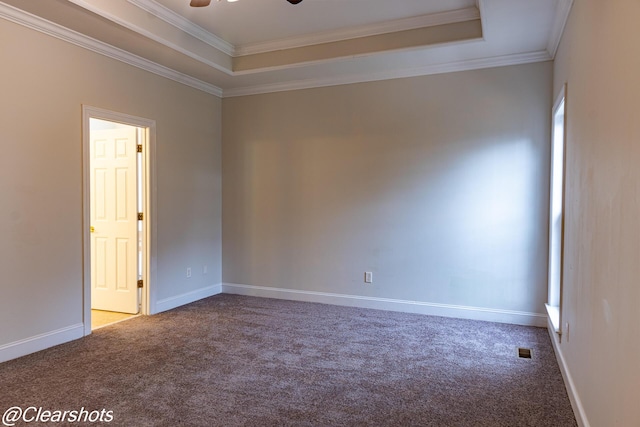 unfurnished room with a raised ceiling, crown molding, and carpet