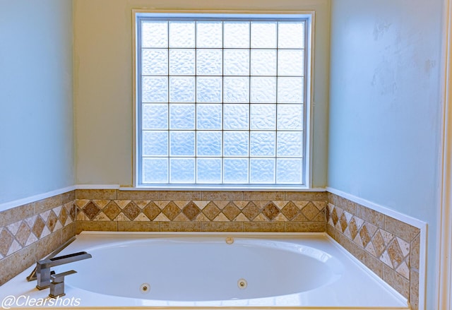 bathroom featuring plenty of natural light and a bath