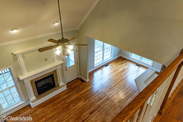 unfurnished living room with ornamental molding, dark wood-type flooring, and ceiling fan