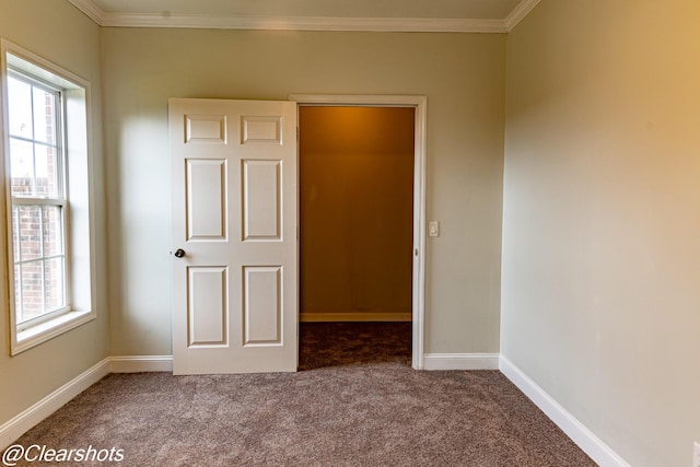 unfurnished bedroom with crown molding, carpet flooring, and multiple windows