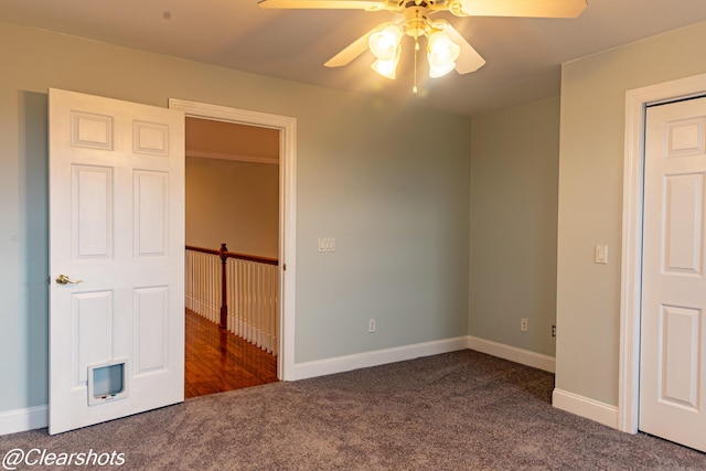 unfurnished bedroom featuring ceiling fan and dark colored carpet