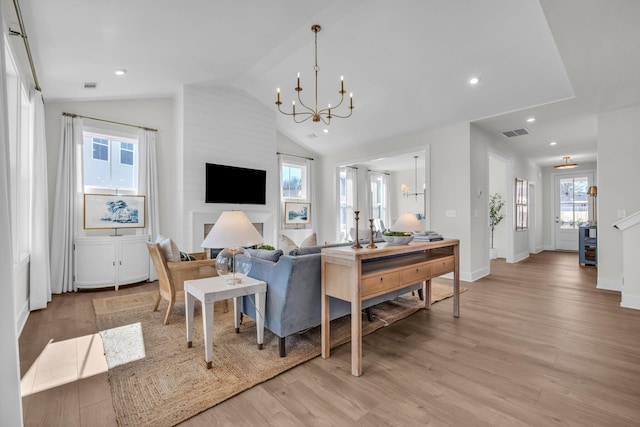 dining space with lofted ceiling, a chandelier, and light wood-type flooring