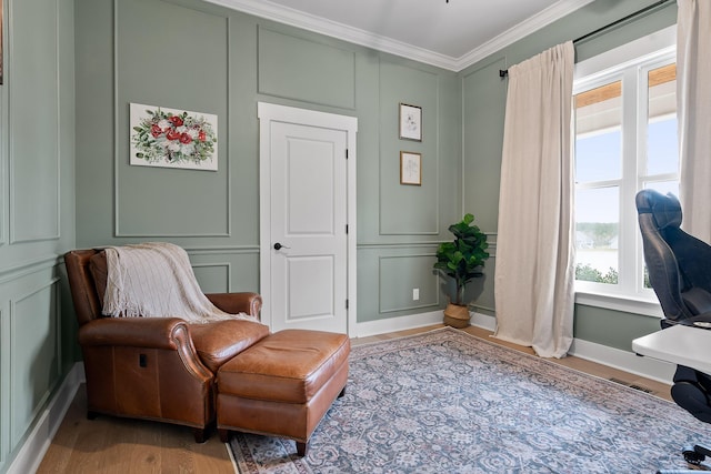 sitting room featuring light hardwood / wood-style flooring and crown molding