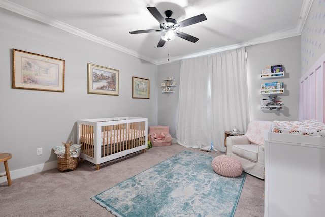 carpeted bedroom with ceiling fan, crown molding, and a crib