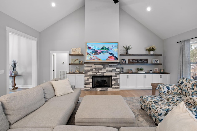 living room with high vaulted ceiling, light hardwood / wood-style flooring, and a fireplace