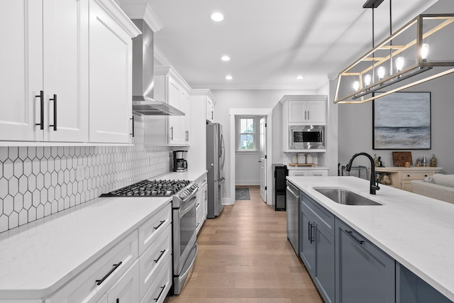 kitchen featuring sink, white cabinetry, hanging light fixtures, and appliances with stainless steel finishes