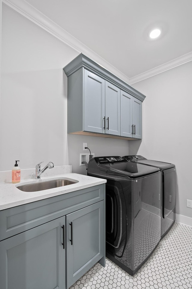 laundry room featuring washer and clothes dryer, cabinets, sink, ornamental molding, and light tile patterned floors