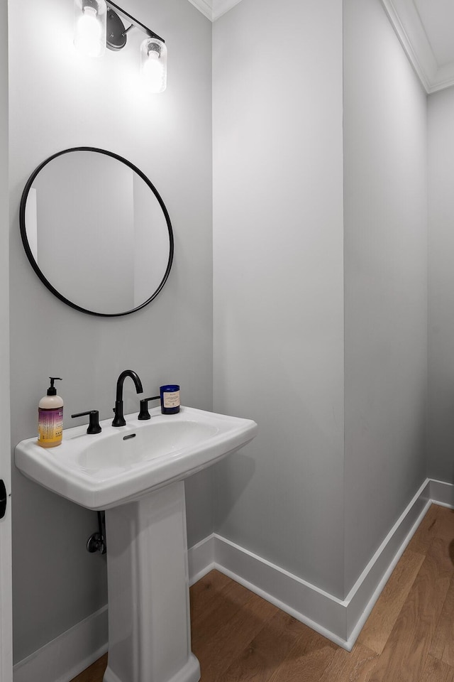 bathroom with crown molding, hardwood / wood-style flooring, and sink