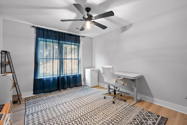 home office featuring wood-type flooring and ceiling fan