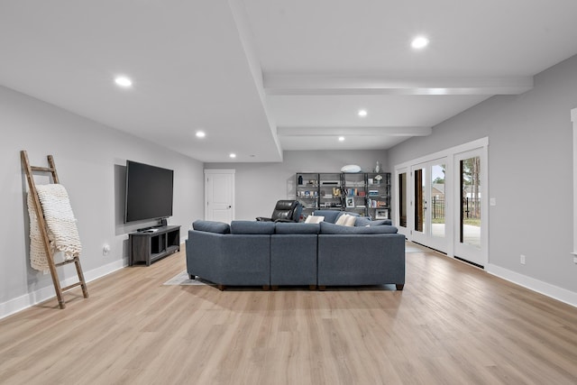 living room featuring beamed ceiling and light wood-type flooring