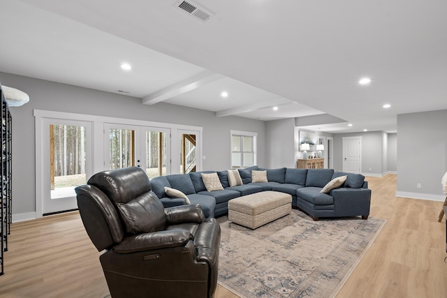 living room with light hardwood / wood-style floors, beam ceiling, and french doors