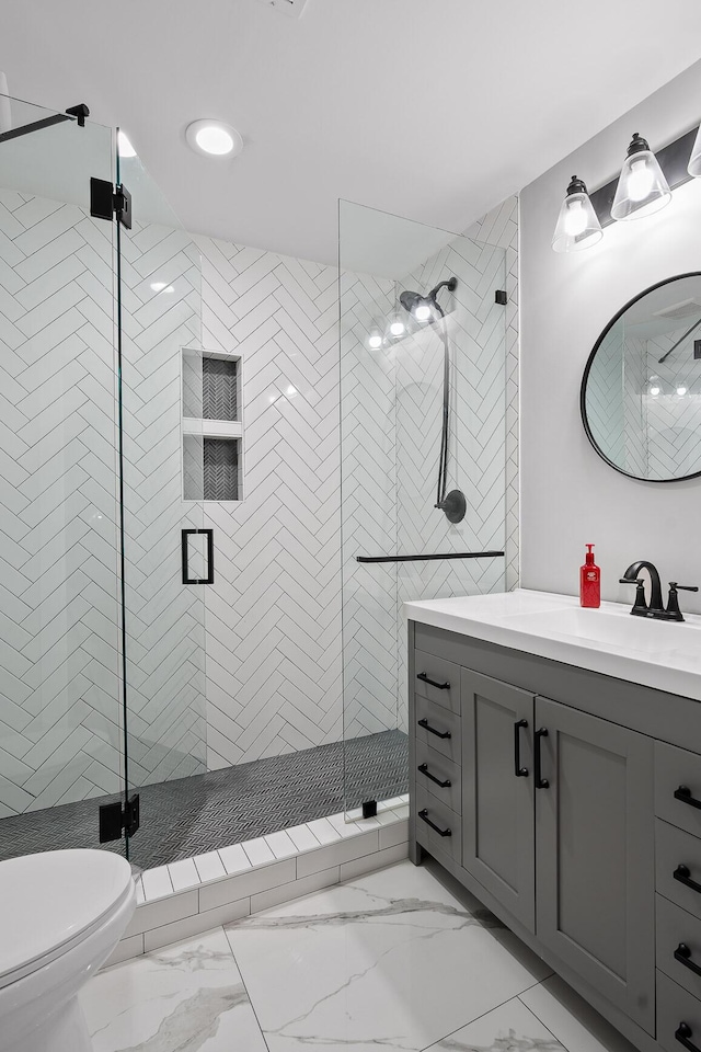 bathroom with vanity, toilet, and a shower with shower door