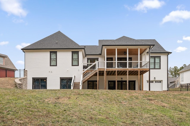 rear view of property featuring ceiling fan, a deck, and a yard