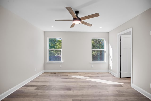 spare room featuring ceiling fan, light hardwood / wood-style flooring, and a healthy amount of sunlight